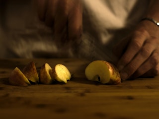 Photo of a apple being cut into wedges.