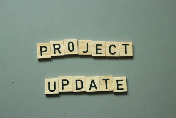 Photo showing 'project update' on Scrabble stones. Photo by Matilda Alloway (@matildaonthemove) on Unsplash.